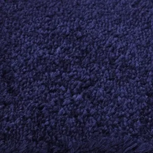 Close-up texture of a luxurious deep pile shag rug or carpet in a rich navy blue or dark indigo color, suitable for upscale Dubai home interiors
