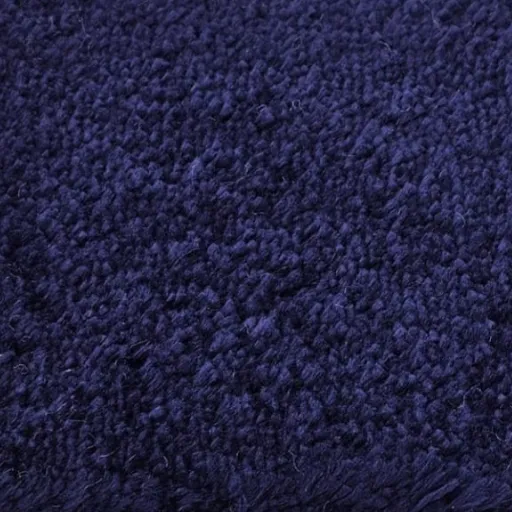 Close-up texture of a luxurious deep pile shag rug or carpet in a rich navy blue or dark indigo color, suitable for upscale Dubai home interiors