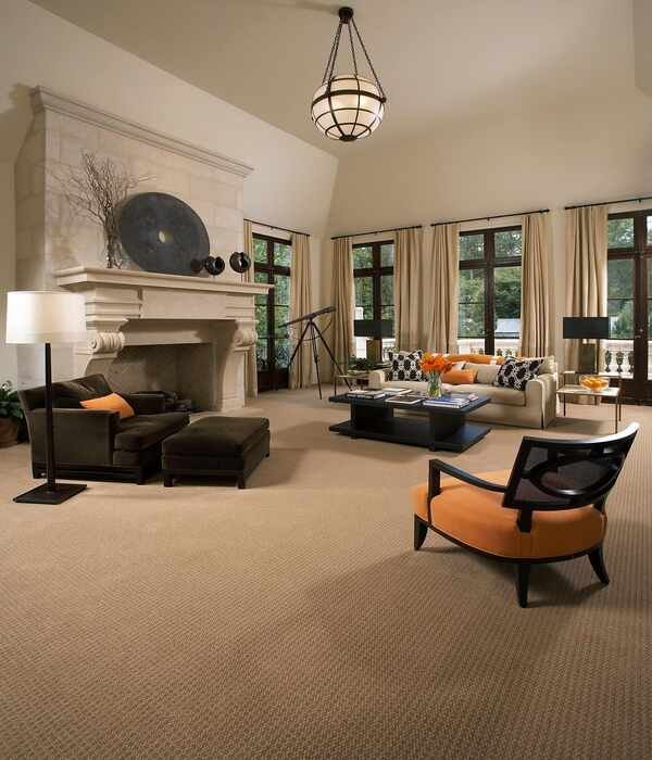 Expansive luxury living room featuring neutral beige wall-to-wall carpet, classic stone fireplace, and high ceilings, reflecting upscale interior design in Dubai villas